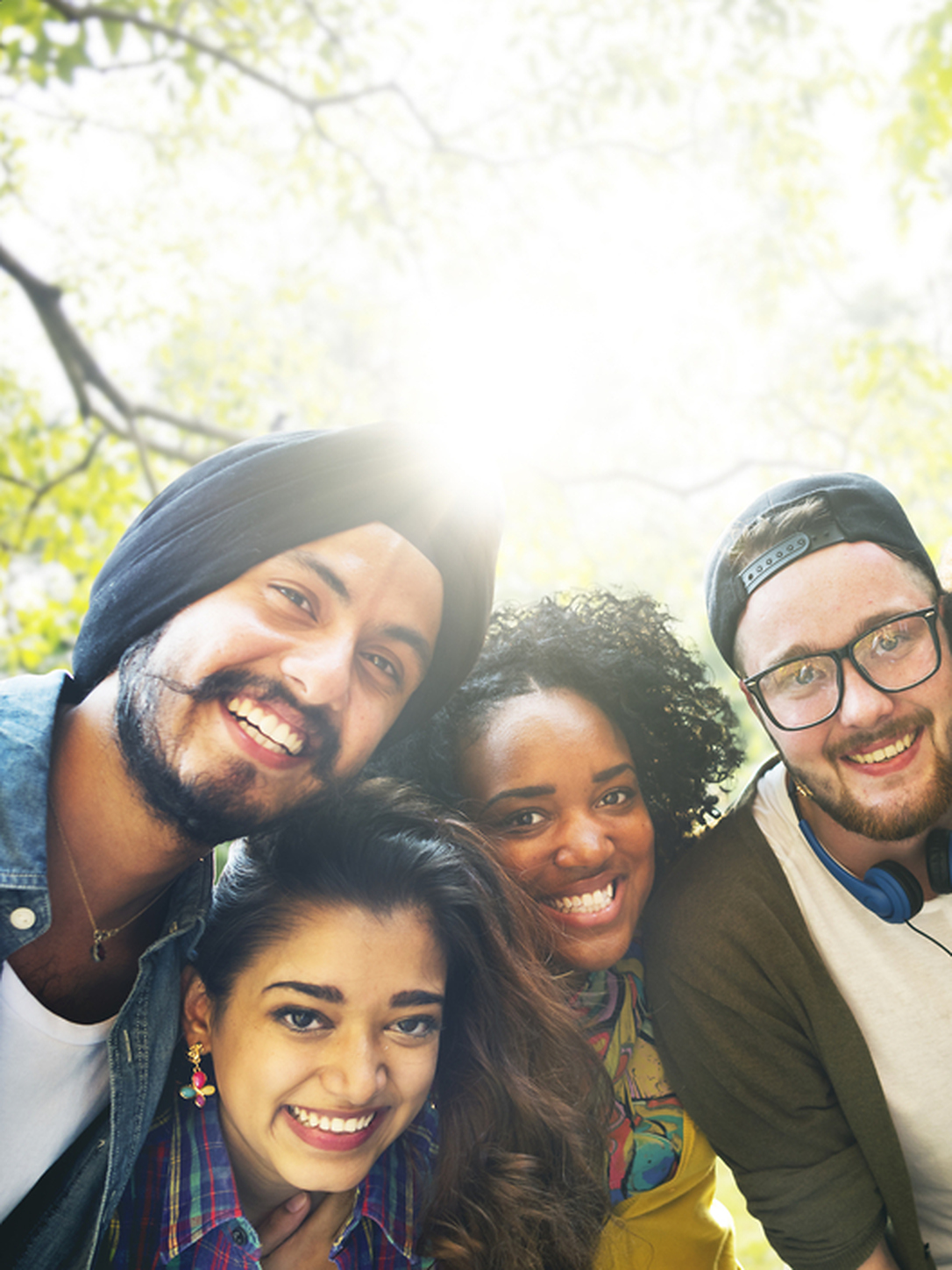 This image shows 4 people with the sun and trees in the background