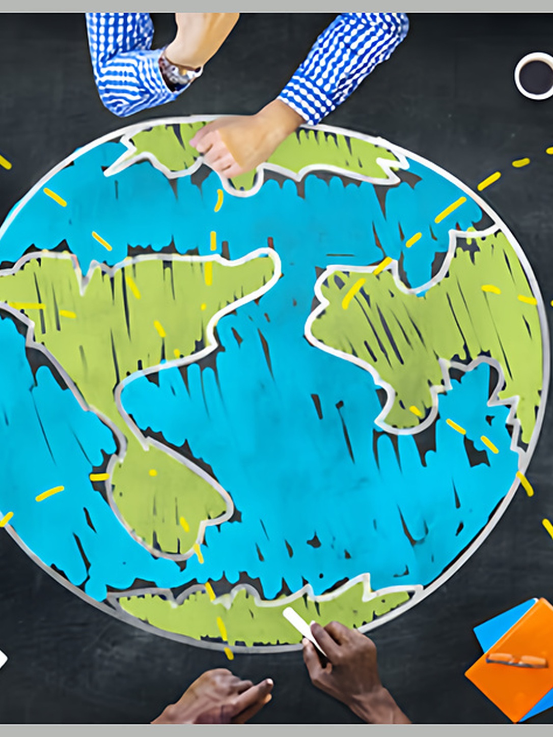 People gather around a chalk drawing of Earth while taking notes.
