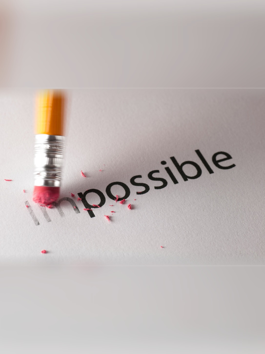 A pencil erases “im” from “impossible” to form “possible.”