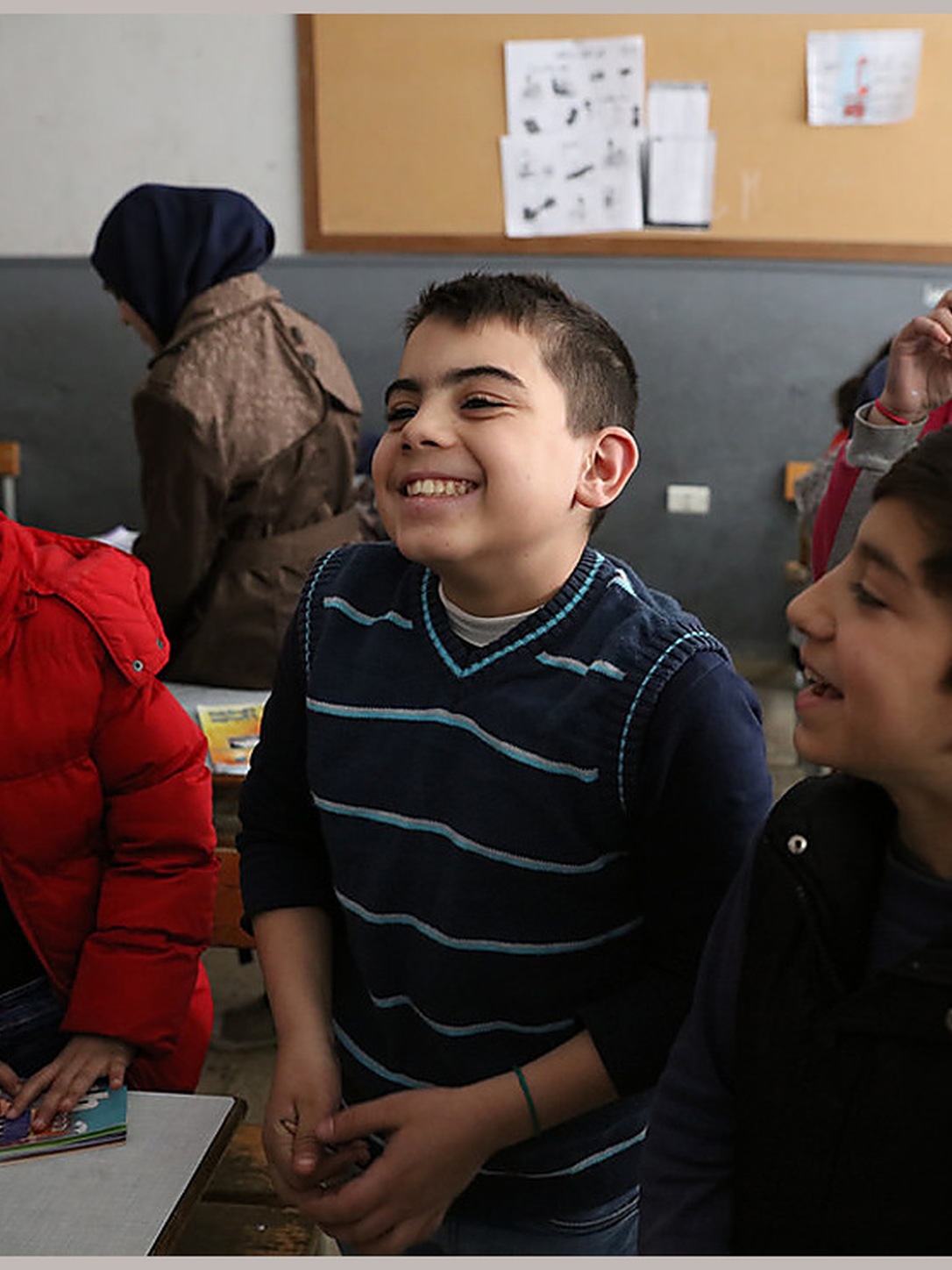 Students smile and laugh together during a classroom activity.