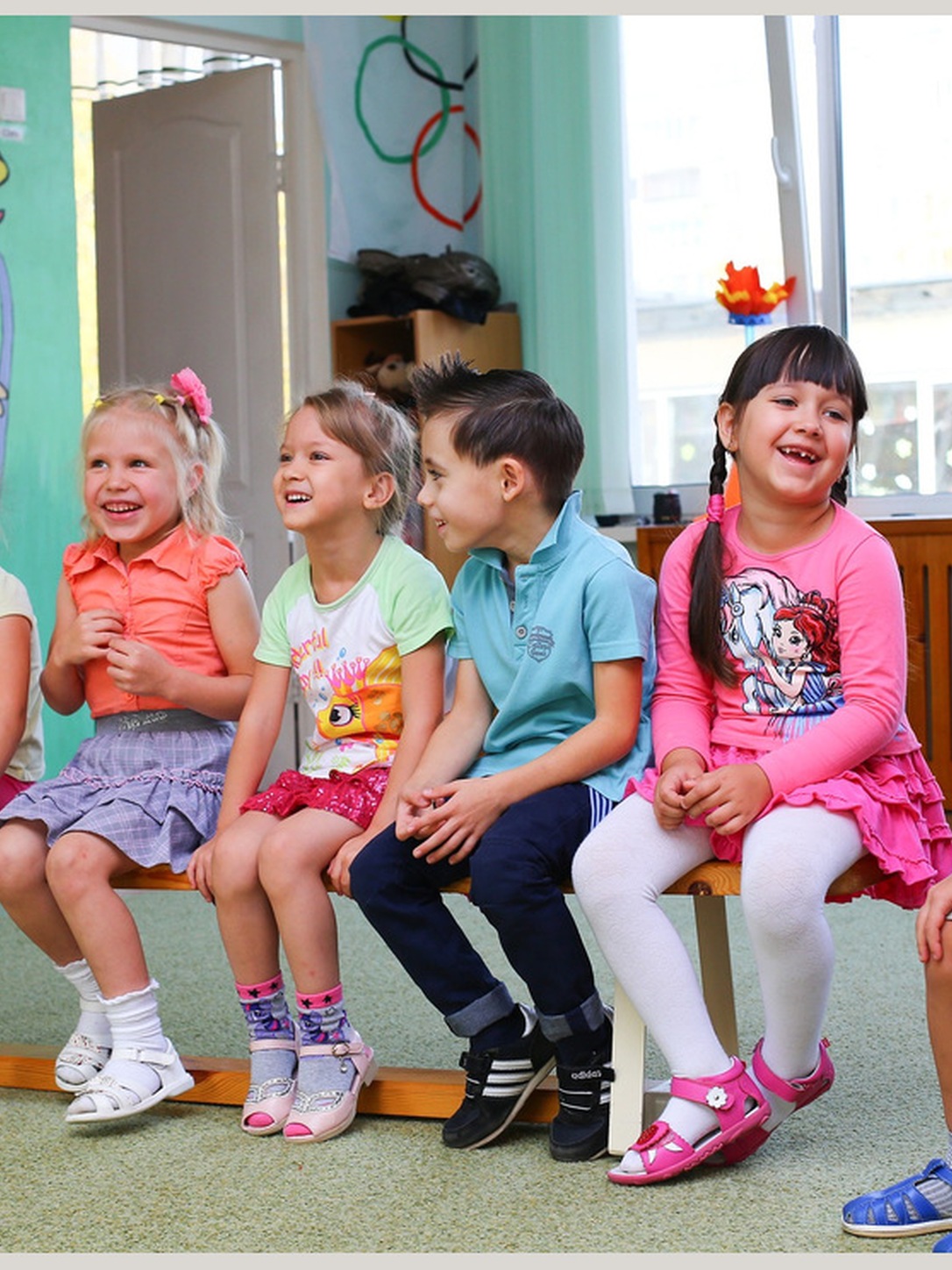Young children laugh together during a classroom activity.