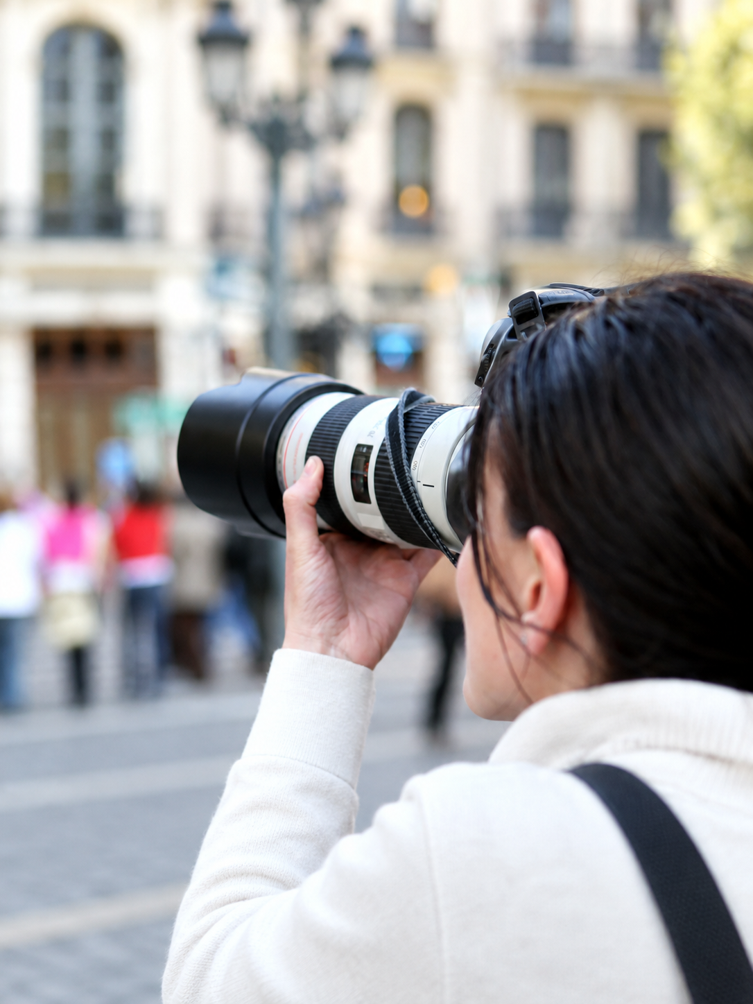 A photographer takes a picture with a telephoto lens.
