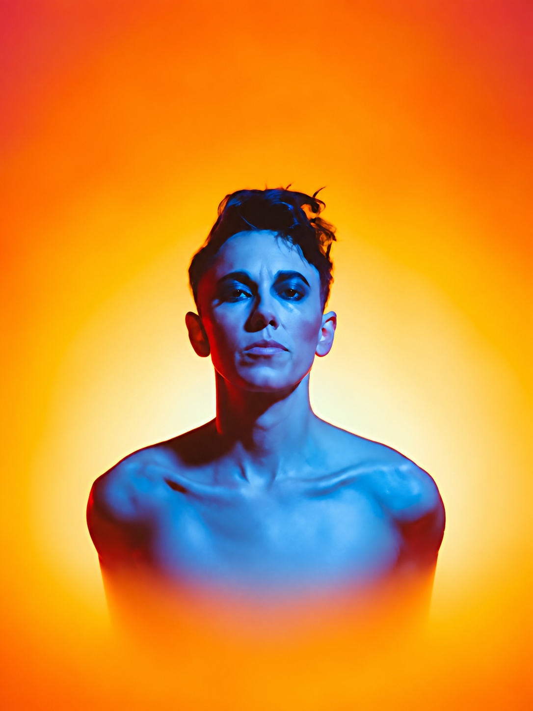 Gina Chavez faces forward in blue light against a glowing orange background.