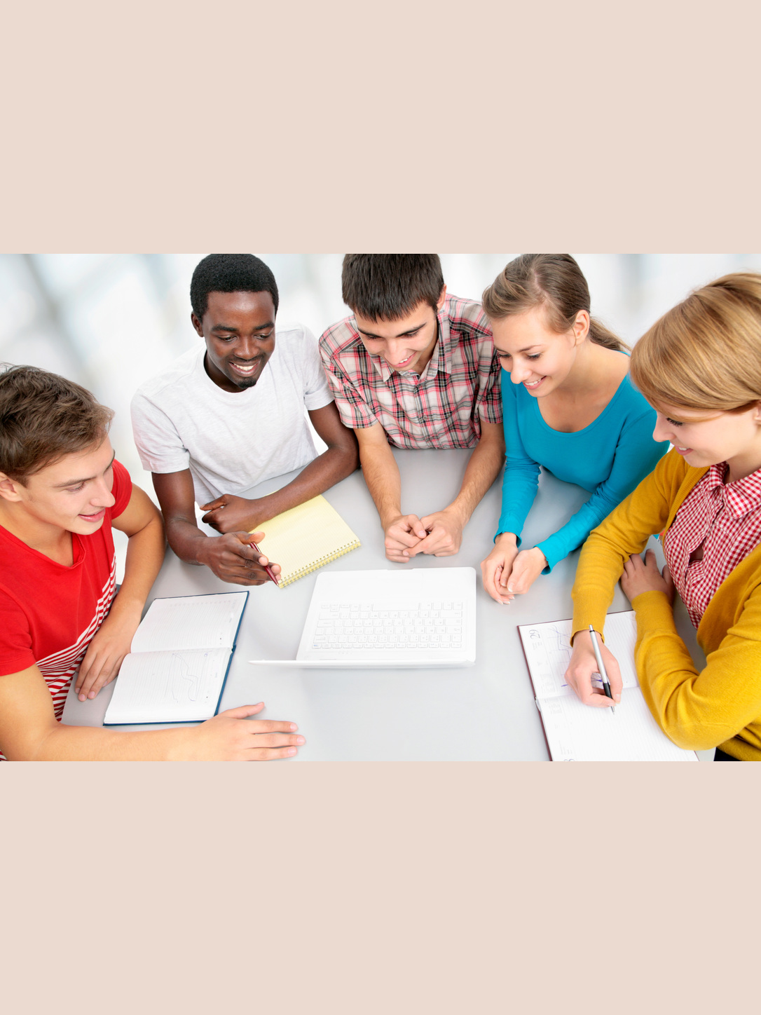 A diverse group of students collaborates around a classroom table.