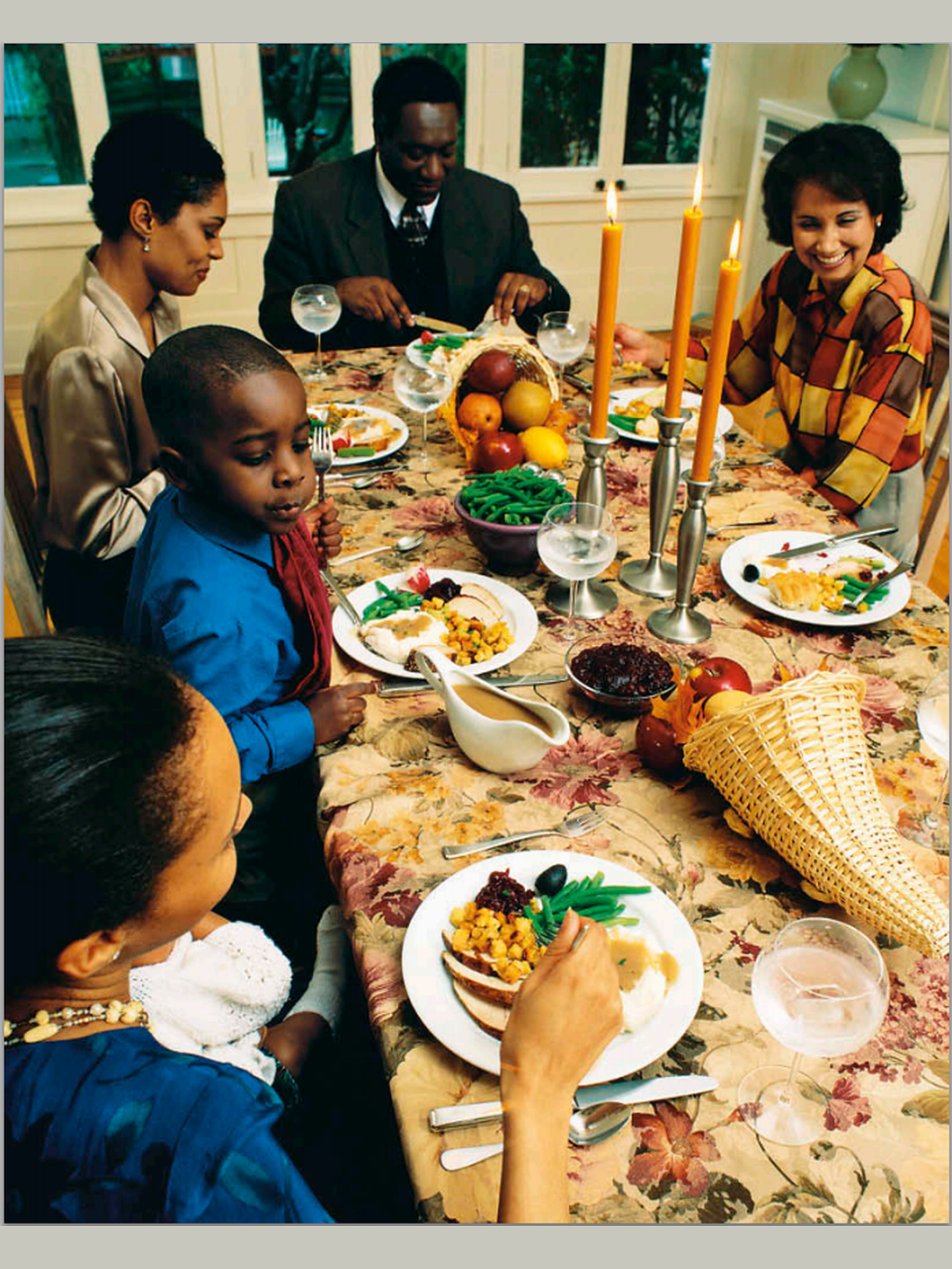 A multigenerational family shares a meal around a dining table.