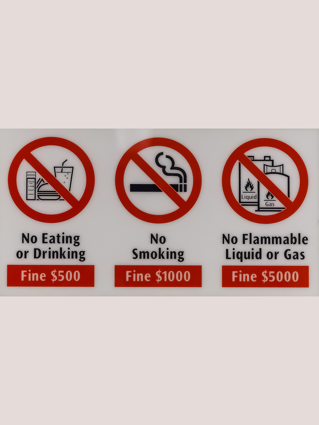 Signs prohibit eating, smoking, and flammable liquids and list fines.