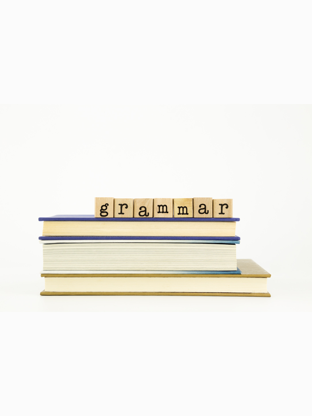 Letter tiles spell "Grammar" on top of a stack of books